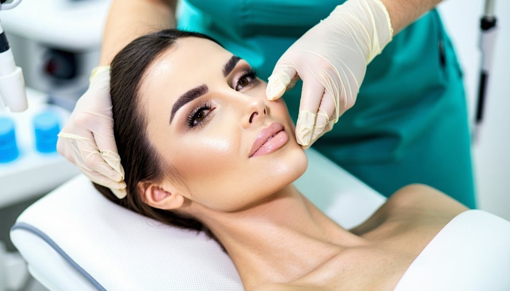 Profissional realizando procedimento estético facial em clínica especializada